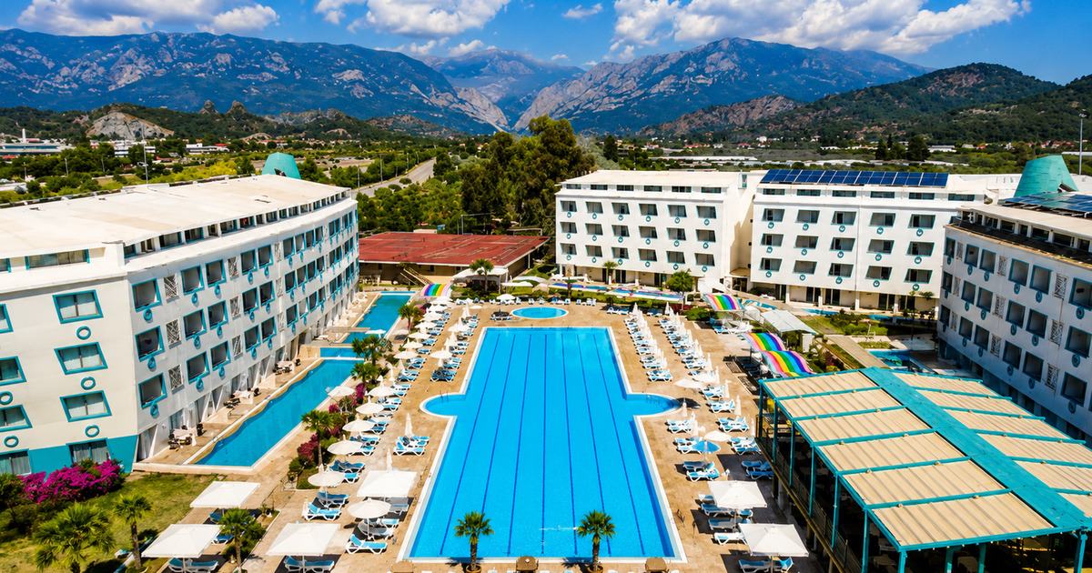 Aerial view of 5-star all-inclusive resort in Kemer with large outdoor pool, sun loungers and Taurus Mountains